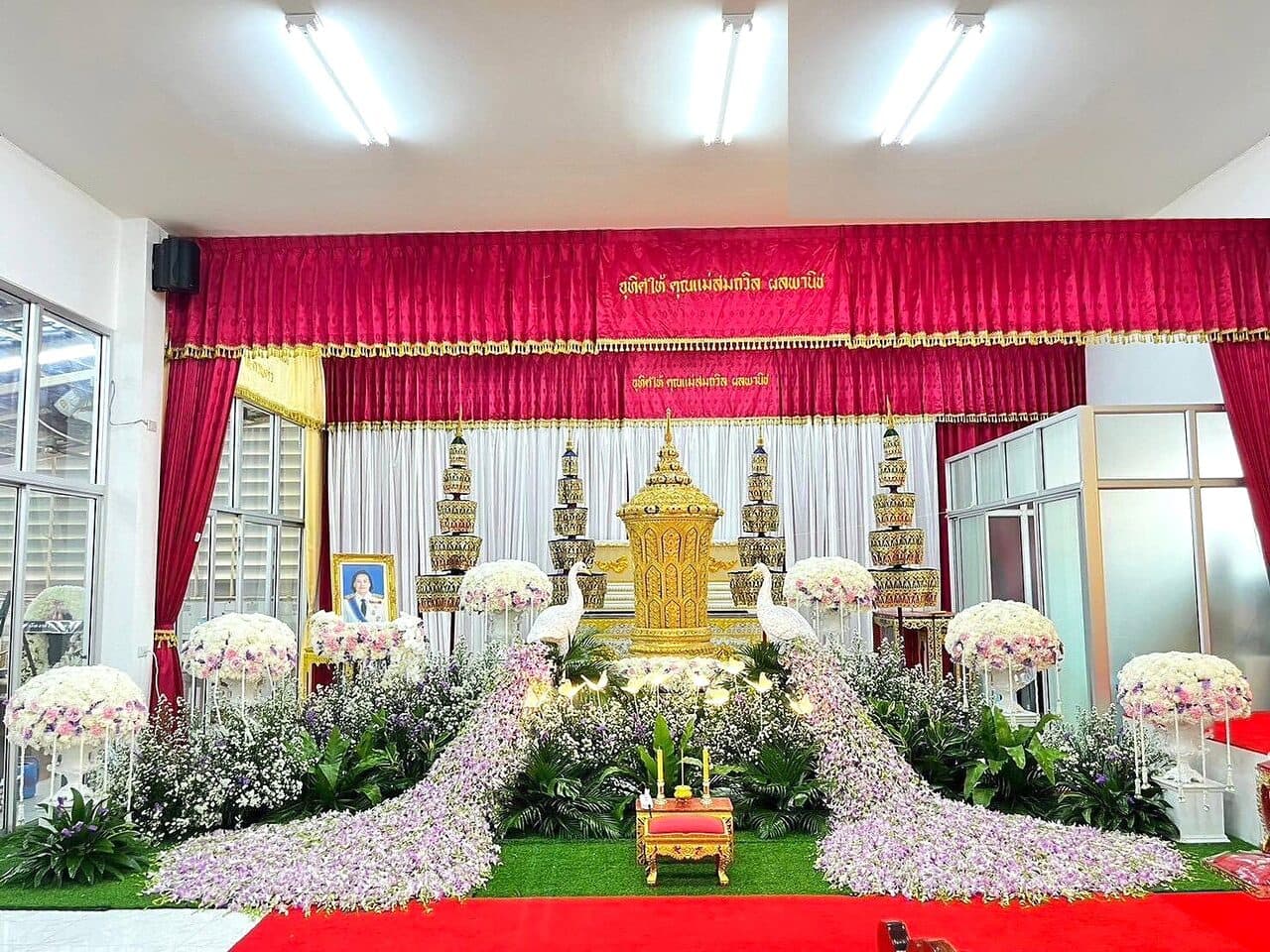 จัดดอกไม้หน้าศพโทนขาว ฉากหลังแดง-ทอง ในศาลาวัด