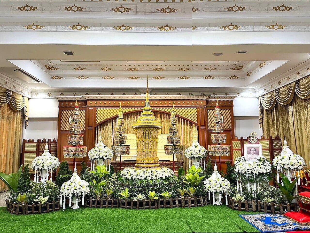 ดอกไม้หน้าศพและฉากหลังเมรุโทนขาว-ทอง ในศาลาไม้