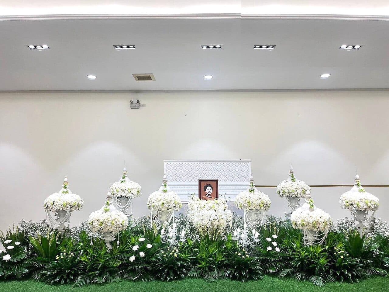 จัดดอกไม้หน้าศพโทนขาวเรียบ ในห้องโถงสว่าง